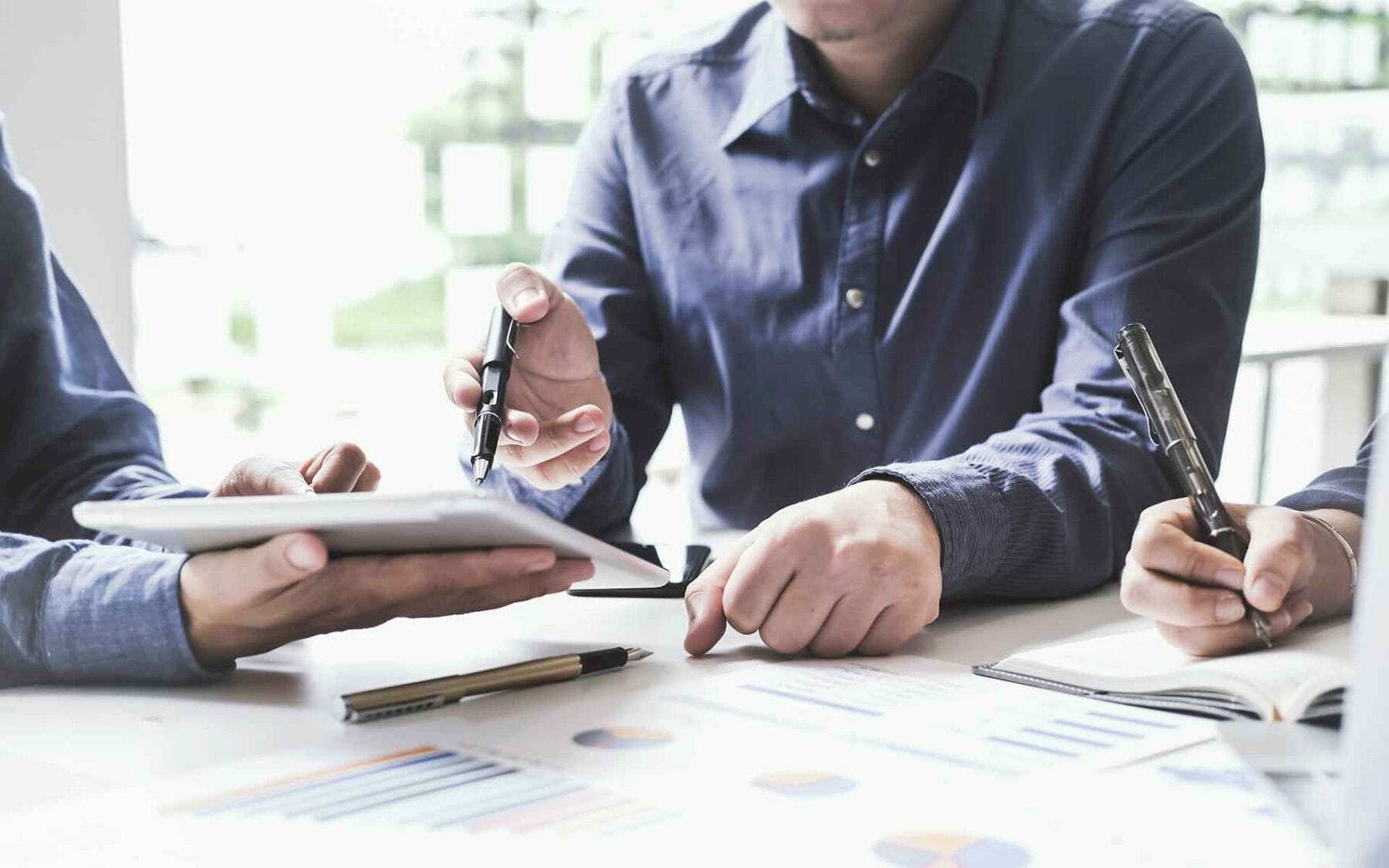 Man pointing to tablet discussing financial investment data